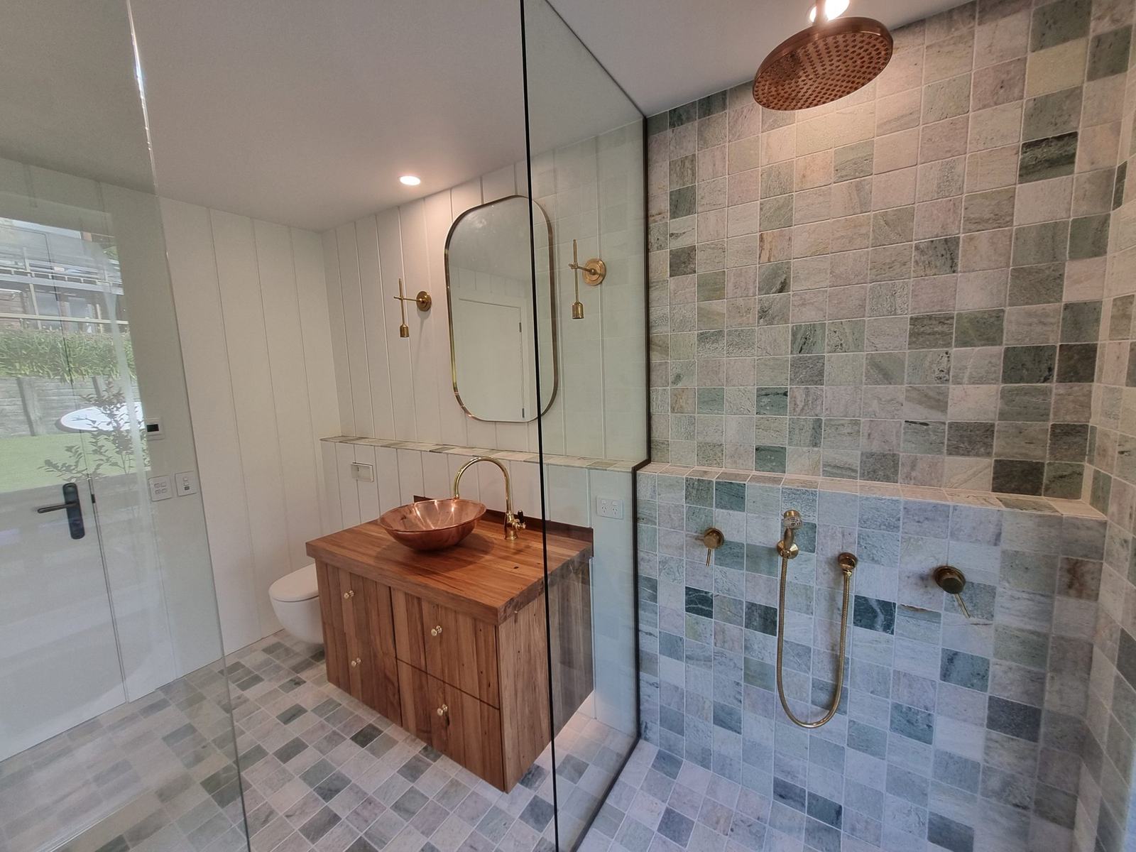 Green natural stone tile bathroom with copper basin