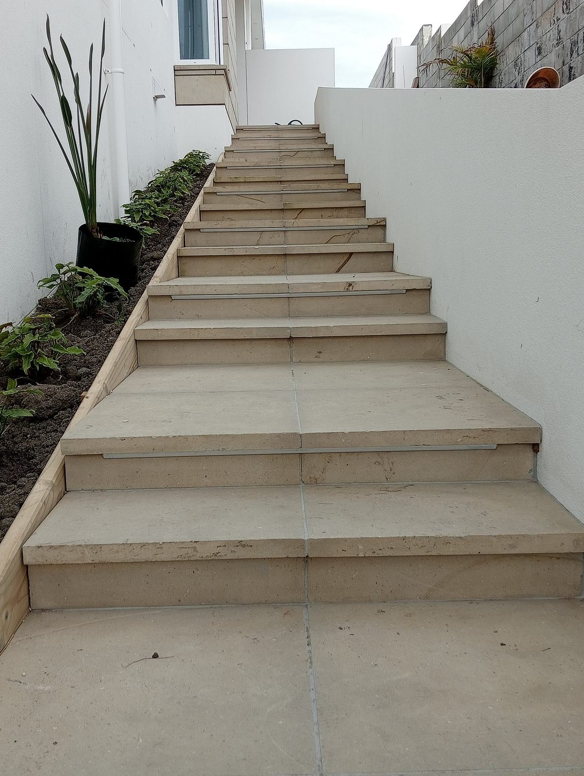 Hinuera stone steps and landing beside a white wall, Wainui, Gisborne