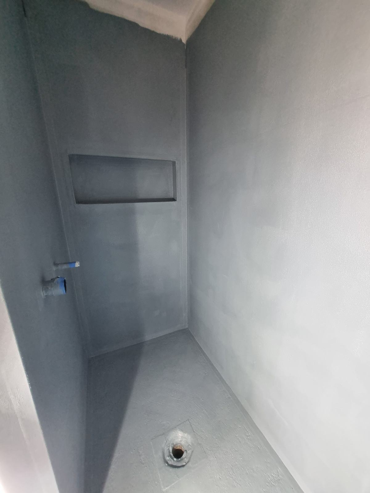 Completed waterproof membrane in a shower with a recessed niche and floor waste