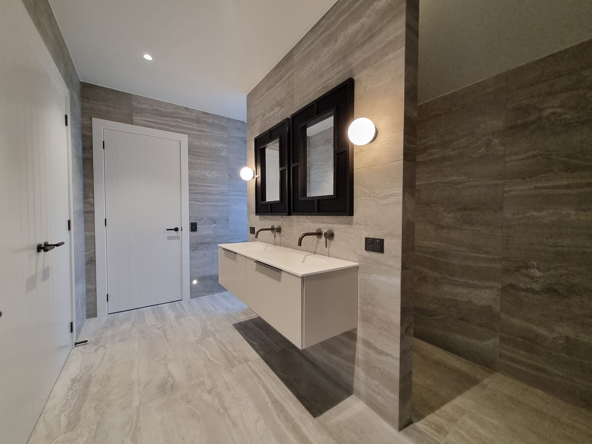 Palmer Mill bathroom with large-format travertine-look tile floor and walls, floating double vanity and an open shower