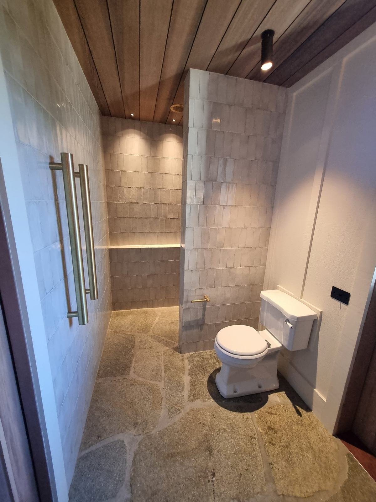 Crazy paving stone floor with zellige-style tiled walls