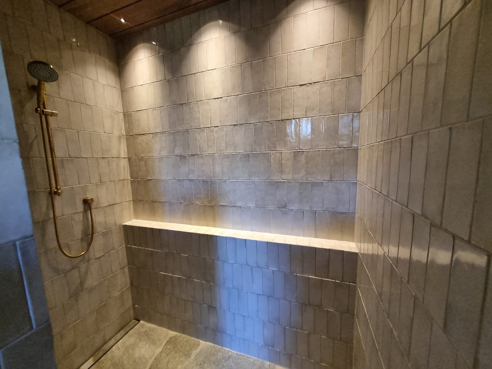 Zellige-style tiled shower with brass fittings